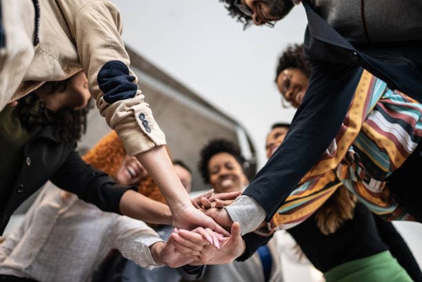 CleanQuest team members joining hands in unity